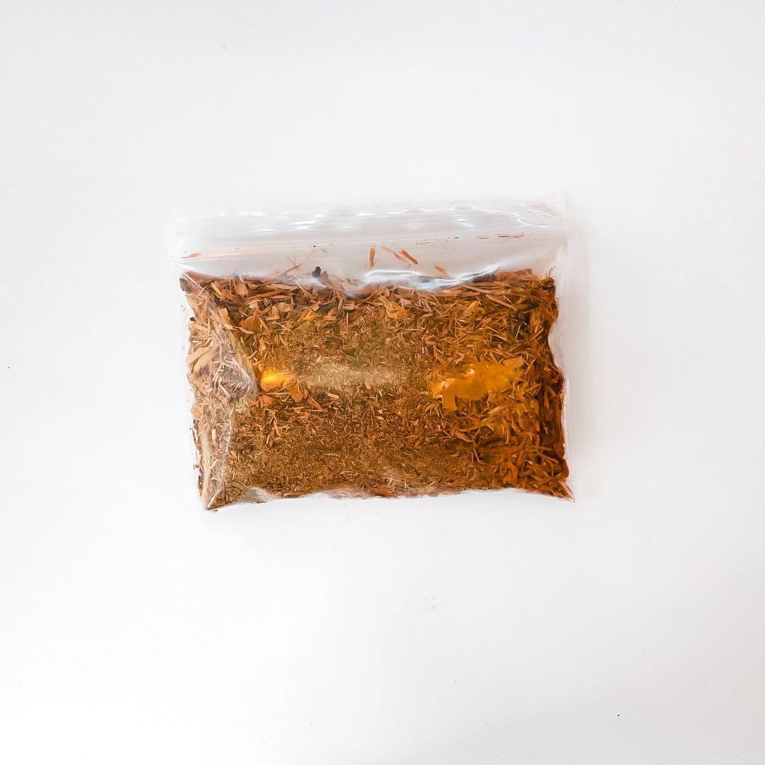 Clear plastic bag of dried nettle leaves with a bright yellow label on a white background