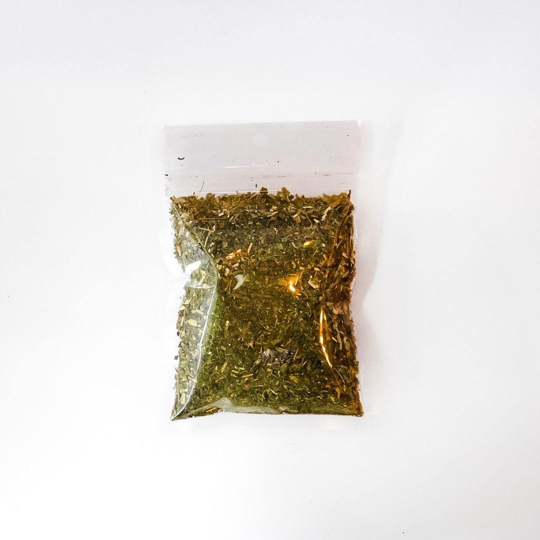 Small clear plastic bag of dried herbs with a bright yellow label on a white background