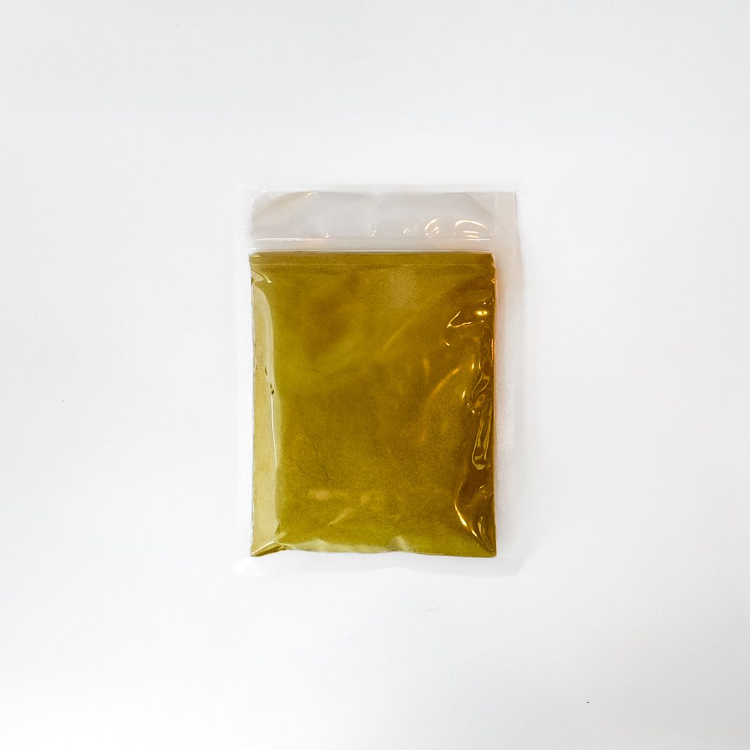 Clear plastic bag of yellow wormwood powder with a bright green label on a white background
