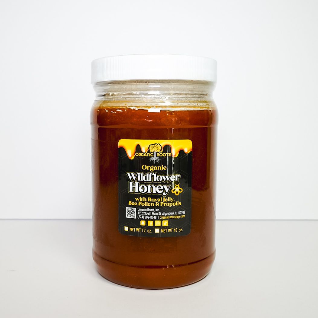 Jar of amber honey with a white lid and black label on a plain white background