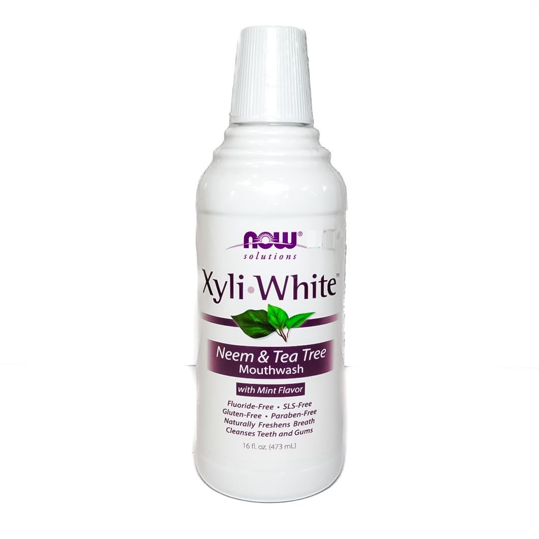 White NOW Xyli-White toothpaste bottle with purple label on a plain background