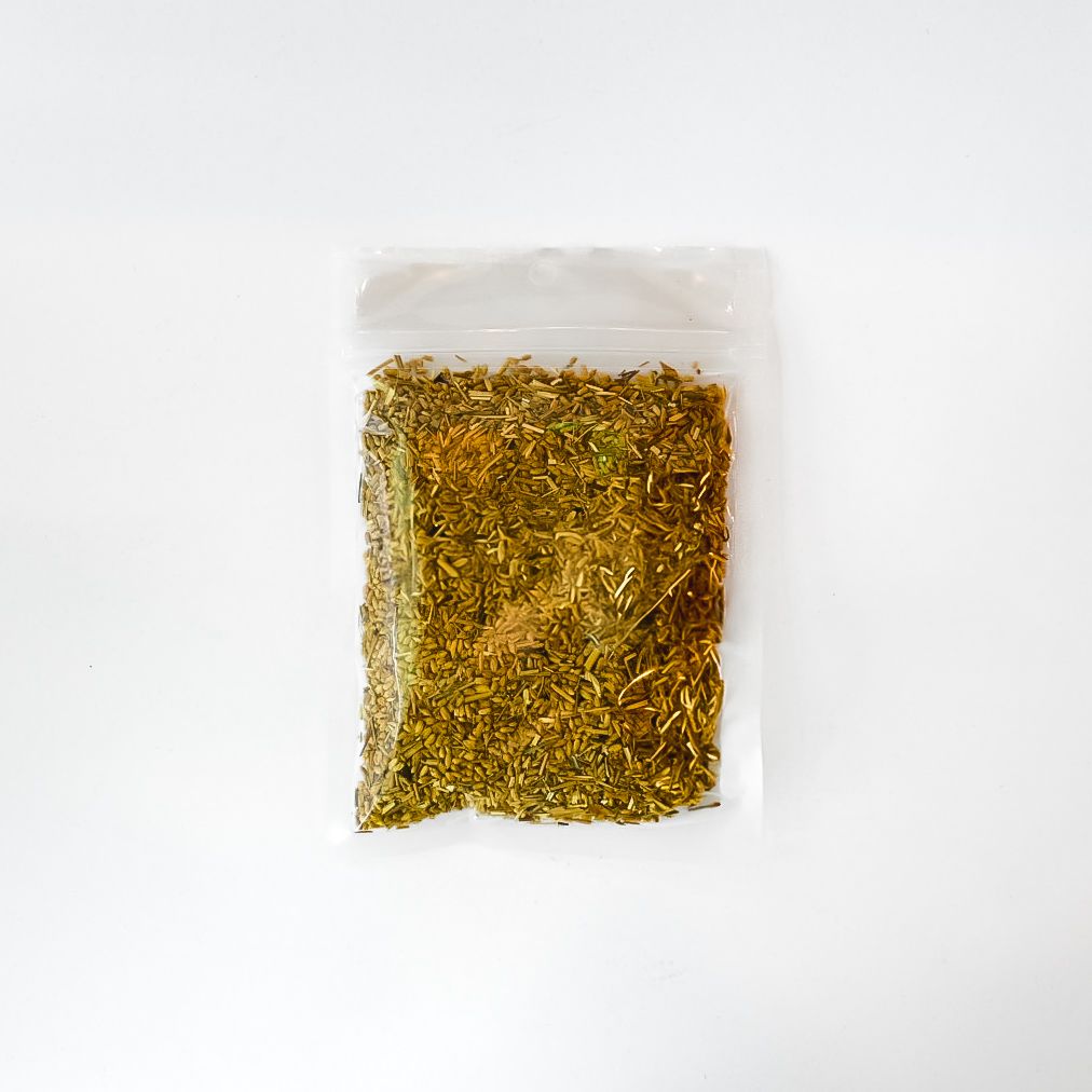 Clear plastic bag of dried yellow flowers with a bright yellow label on a white background