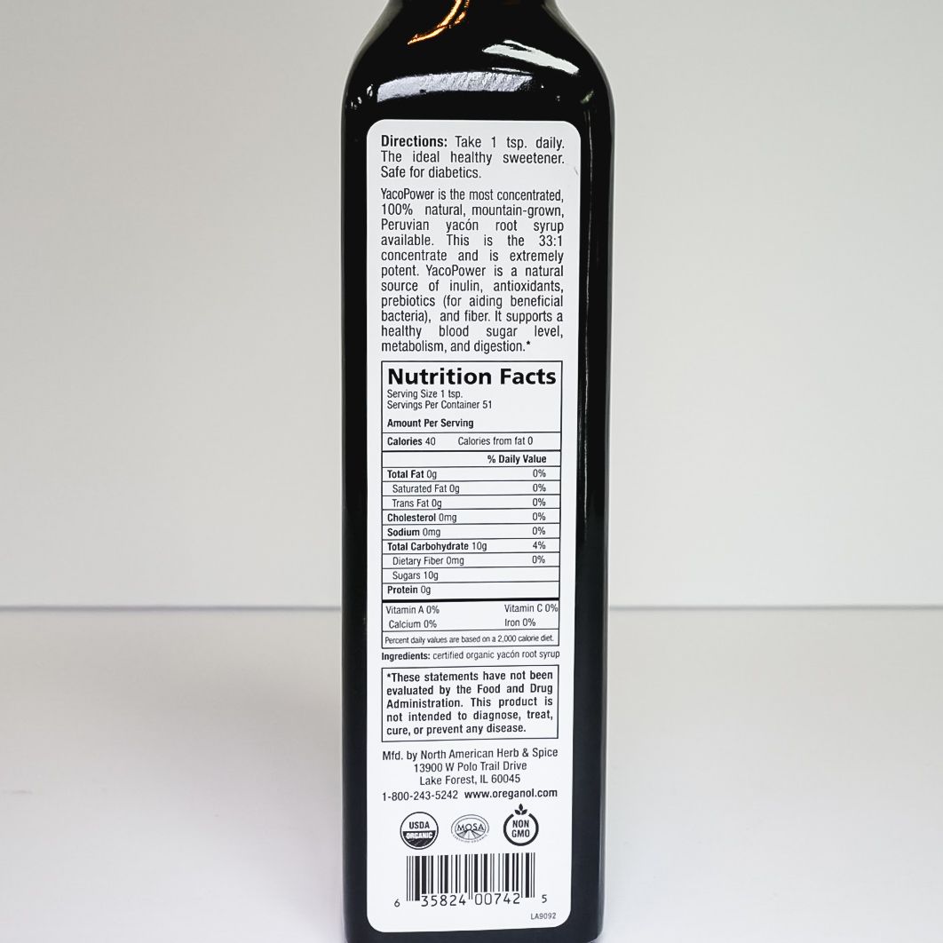 Tall dark glass bottle with a black cap and orange label on a white background