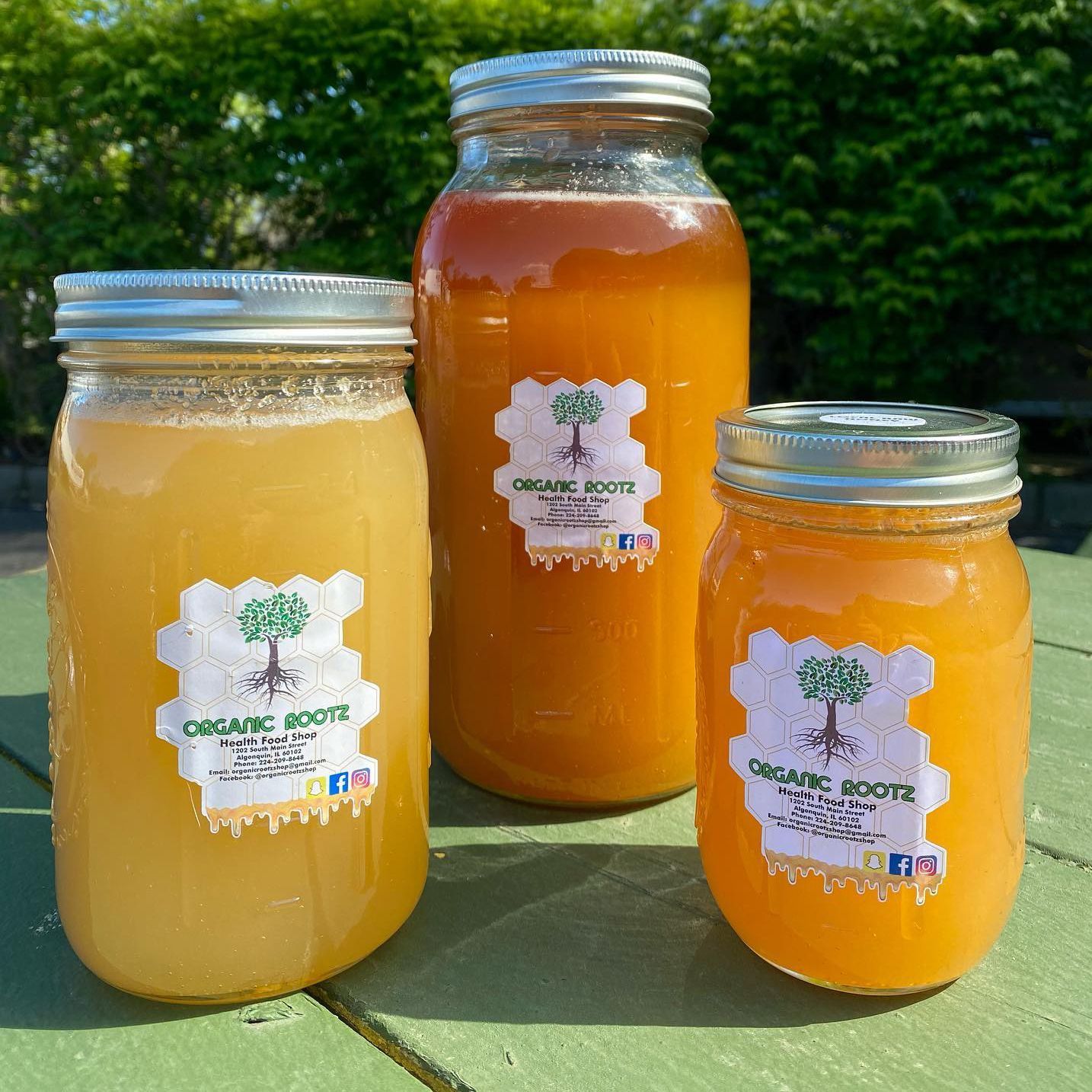 three jars of honey are sitting on a green table .
