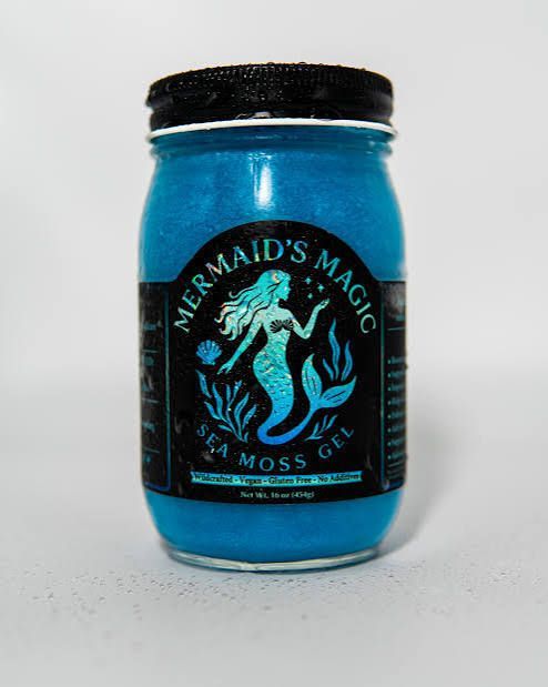Blue jar labeled “Mermaid’s Magic Moss” with a black lid and mermaid graphic