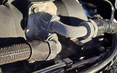 Close-up of black automotive hoses and metal fittings in an engine compartment