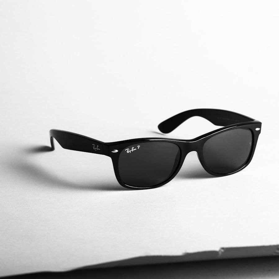 Black sunglasses on a white surface, shown at an angle with one temple raised
