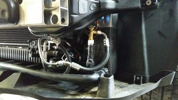 Close-up of engine components with hoses and wiring inside a vehicle compartment