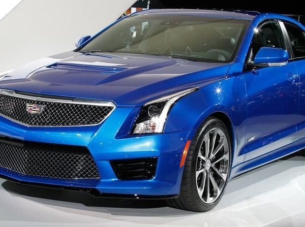 Blue Cadillac sedan displayed in a showroom, front-left view