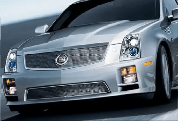 Silver Cadillac sedan driving on a road, front view with headlights on