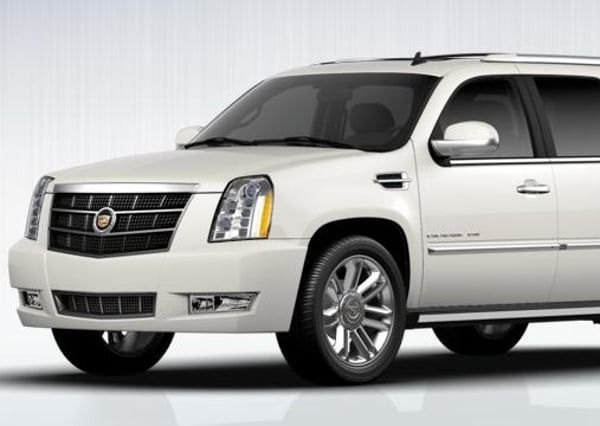 White Cadillac SUV in a studio setting, front view angled left
