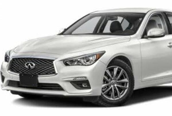White Infiniti sedan in a studio setting, front three-quarter view