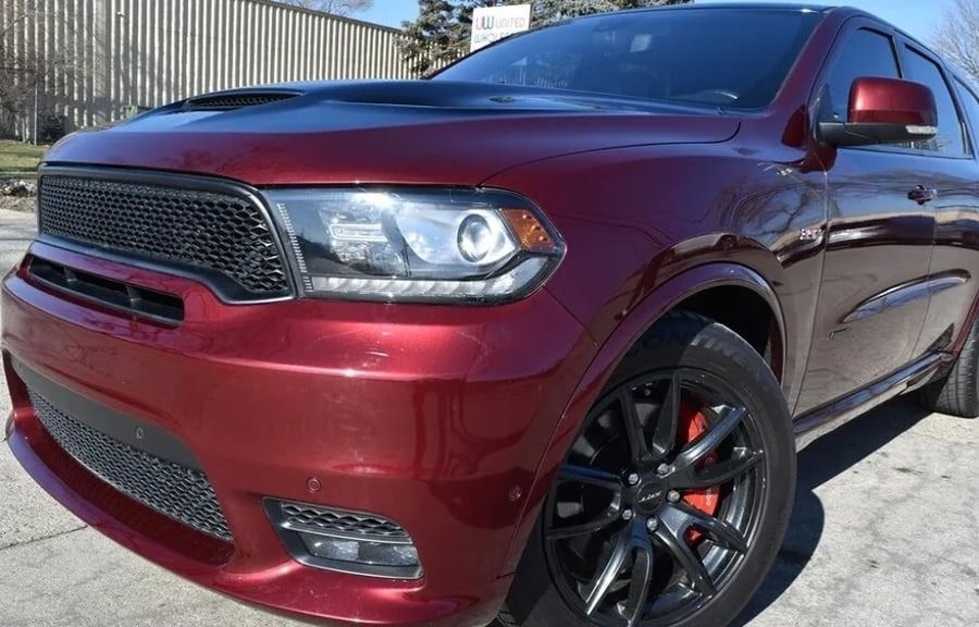 Maroon SUV parked outdoors, front-left view, with black rims and a chrome grille