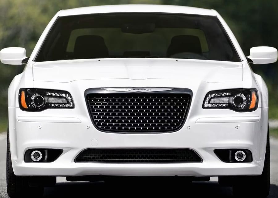 Front view of a white Chrysler sedan against a black background