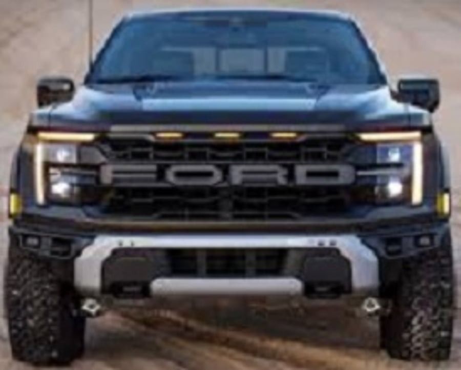 Front view of a black pickup truck with off-road tires on a dirt road