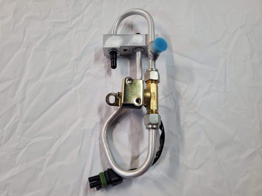 Coiled metal tubing with valves and fittings on a white background