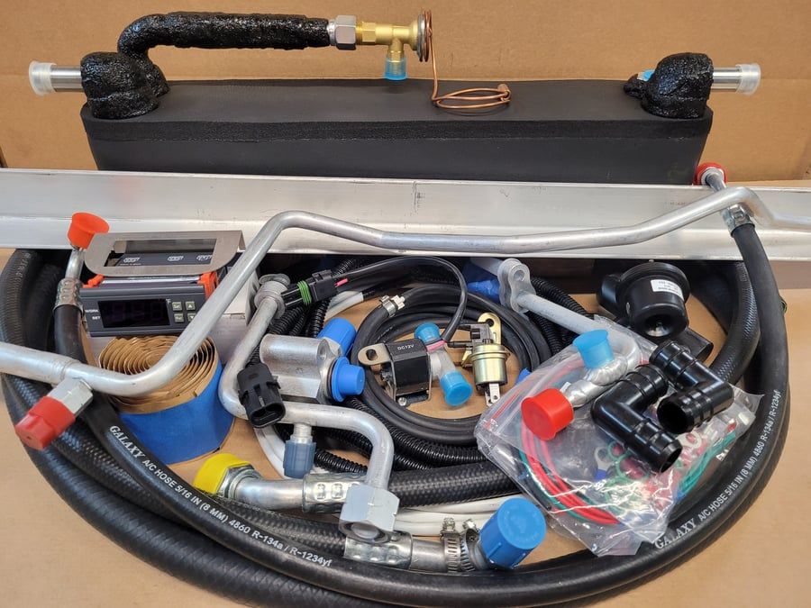 Open toolbox with assorted hoses, metal fittings, and plastic parts neatly packed inside