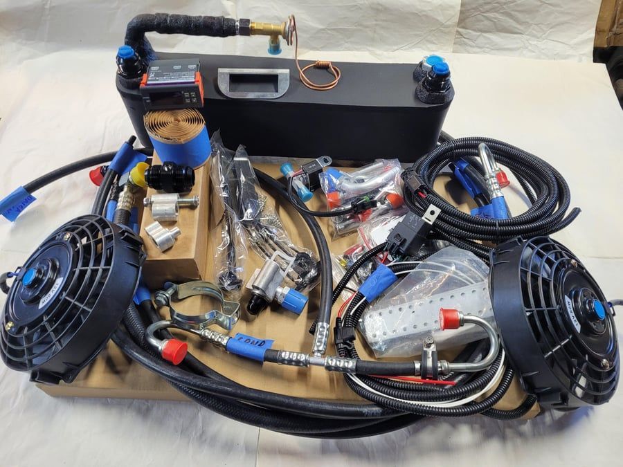 DIY portable cooling setup with two black fans, coiled tubing, wiring, and a small tank on a cart