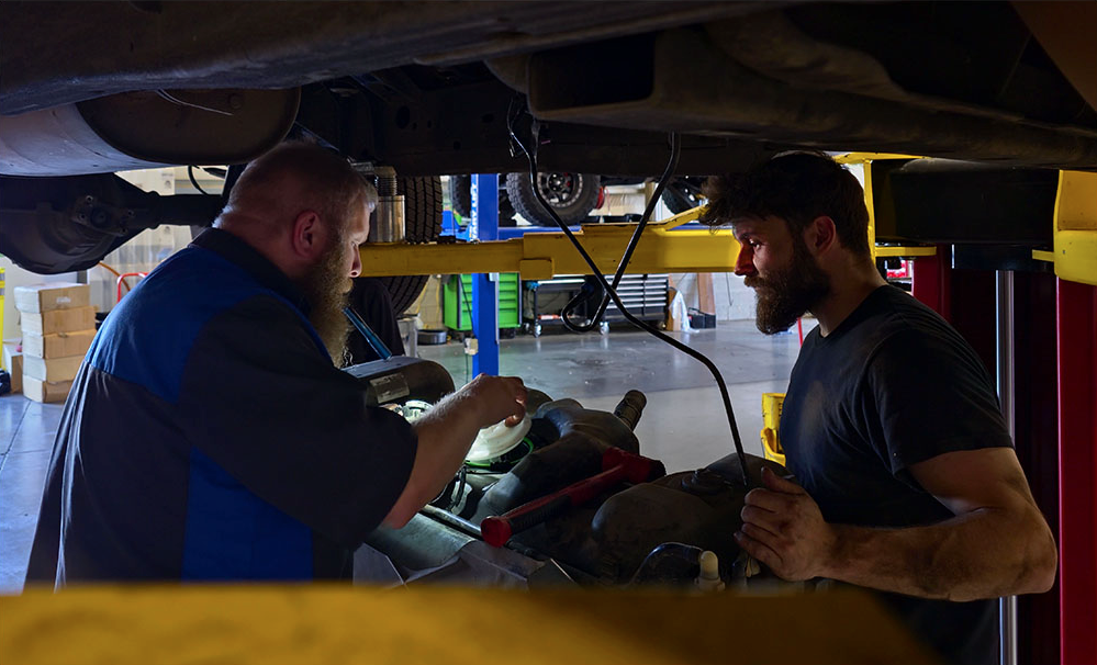 Two mechanics working under a car | Willamette Automotive Care