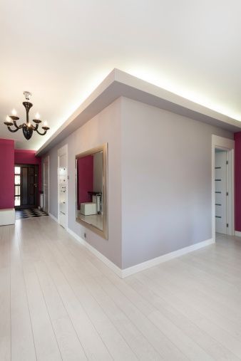 A man is standing in an empty room with a ladder.