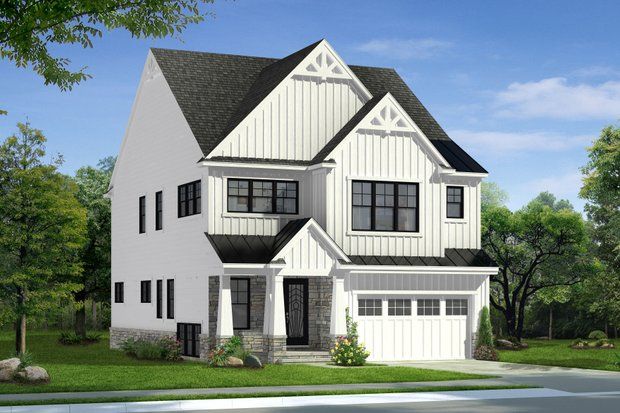 Two-story white house with black trim and a two-car garage, set in a grassy yard.