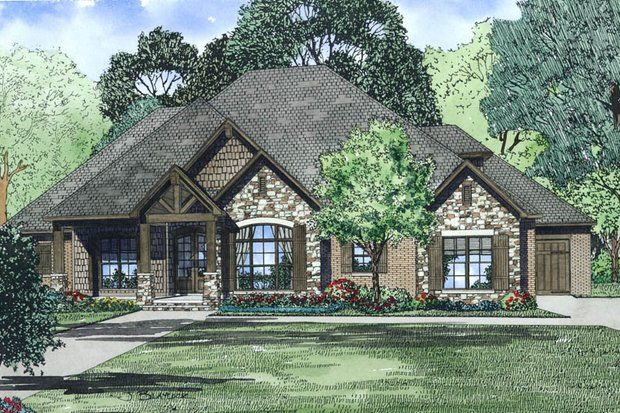 Stone and brick house with dark roof, gables, and trees in a grassy yard.