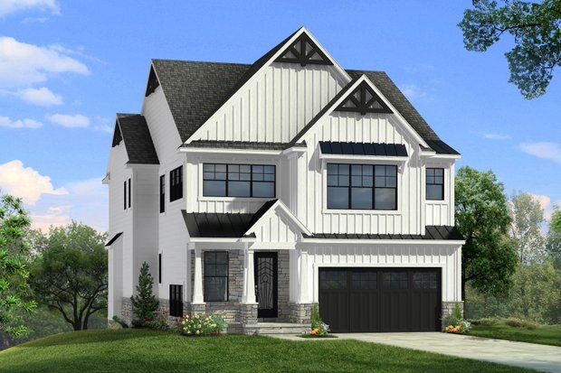 Modern white house with black accents, stone accents, and a black garage door.