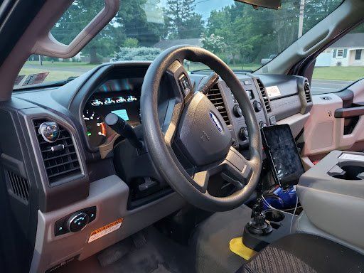 The interior of a ford truck with a steering wheel and dashboard.