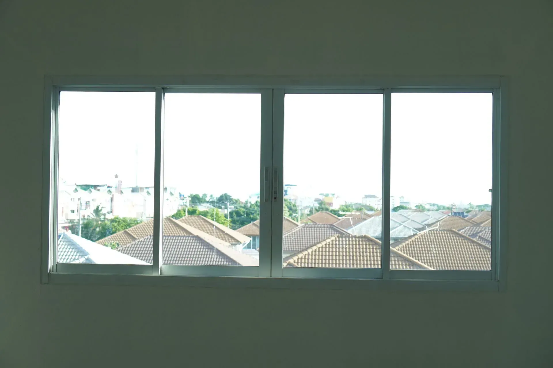 Window overlooking rooftops, with a white frame and clear panes.