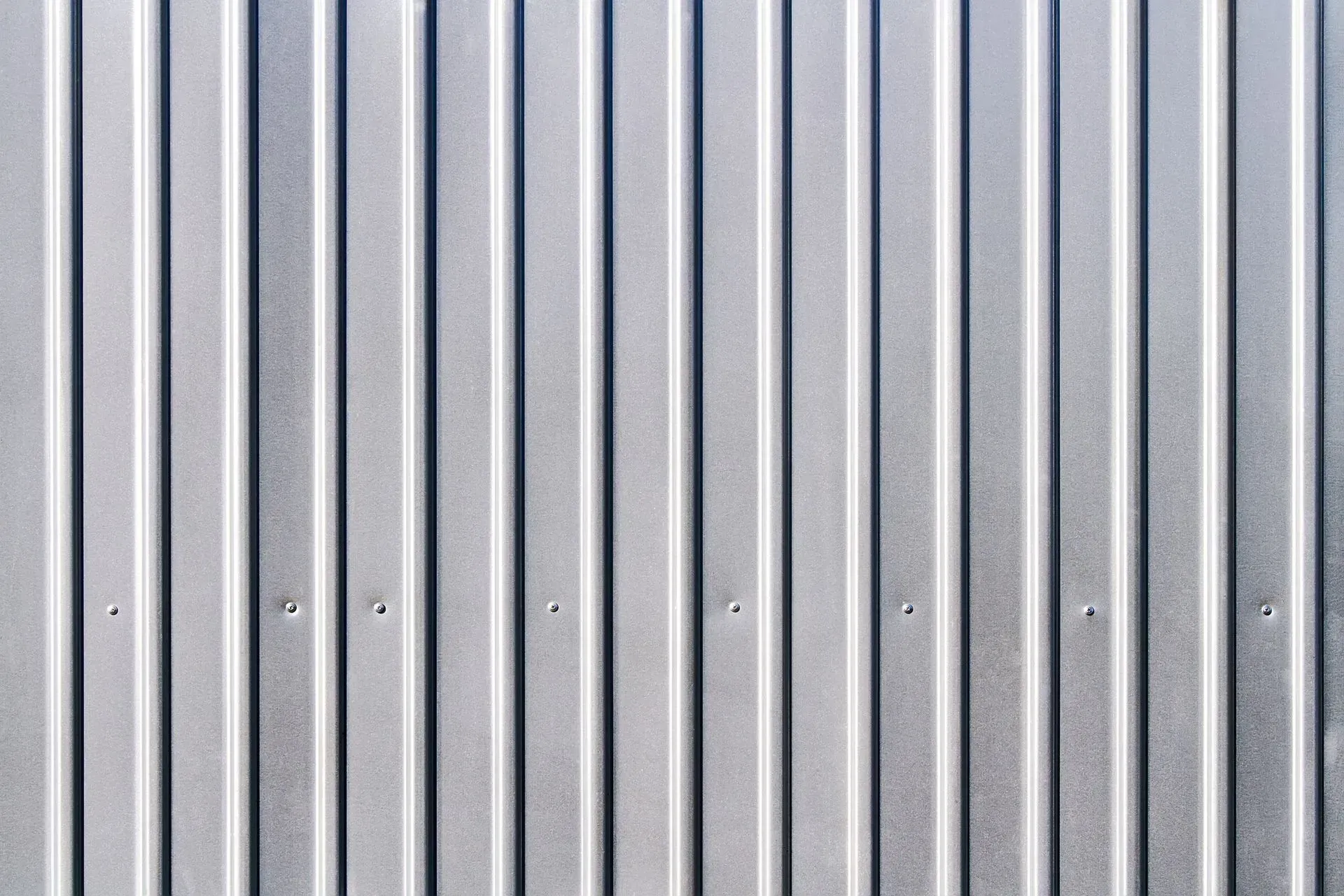 Exterior Services. Vertical corrugated metal siding, silver-gray.