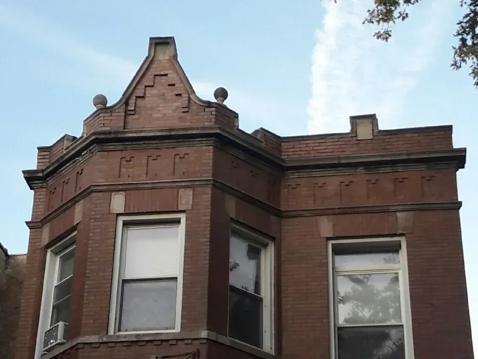 Gallery. Red brick building facade with bay windows, decorative brickwork, and a gabled top.