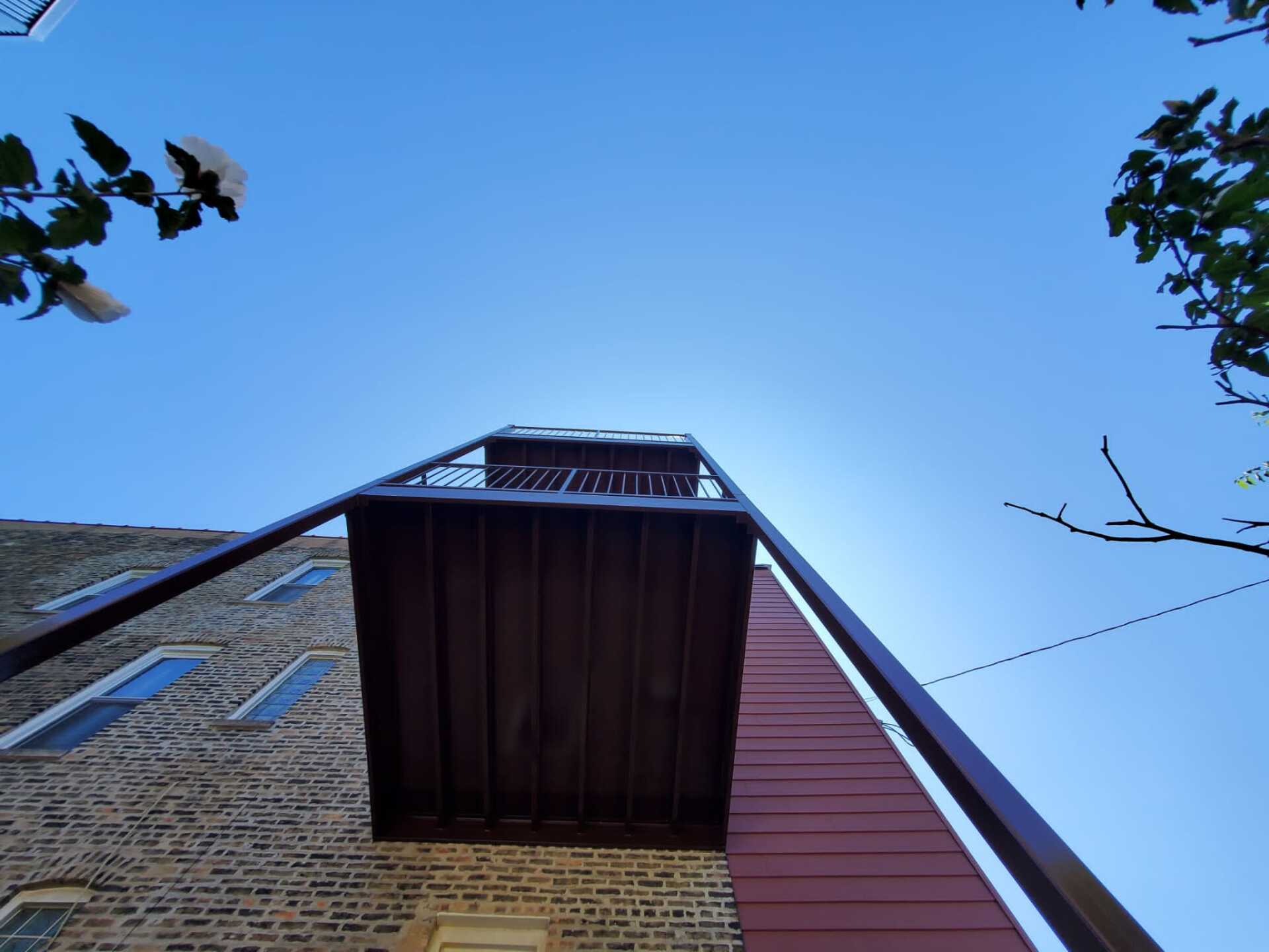Looking up at a fire escape on the side of a building