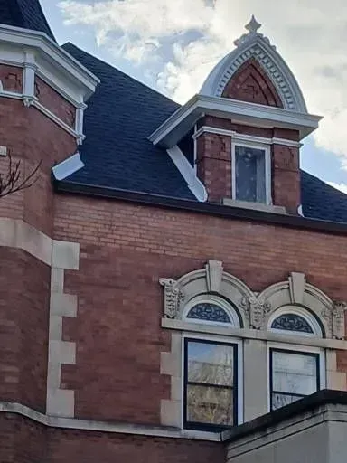 Gallery. Red brick building with decorative white trim and a black roof.