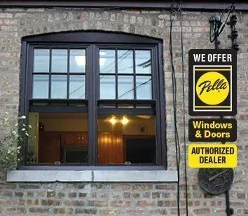 Brown Pella double-hung window on brick building with sign: 