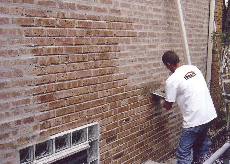 A man is working on a brick wall with a trowel