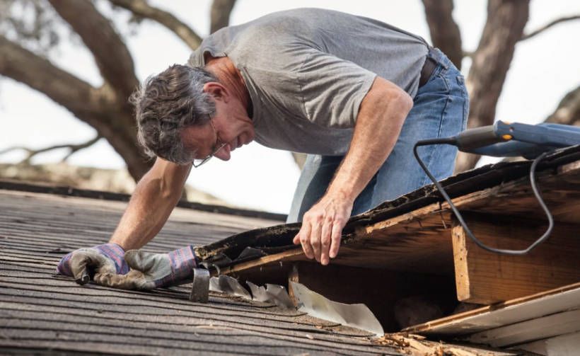 A man is working on the roof of a house.