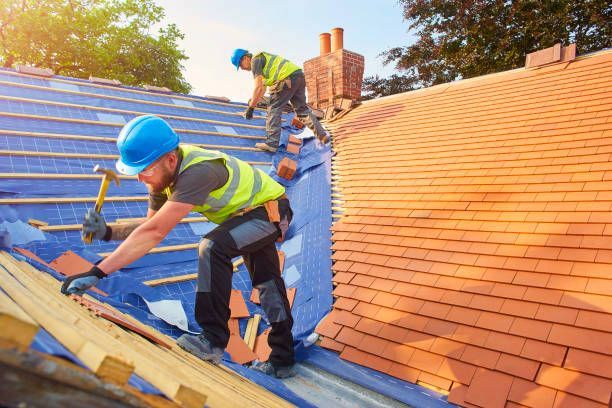 Two men are working on the roof of a house.