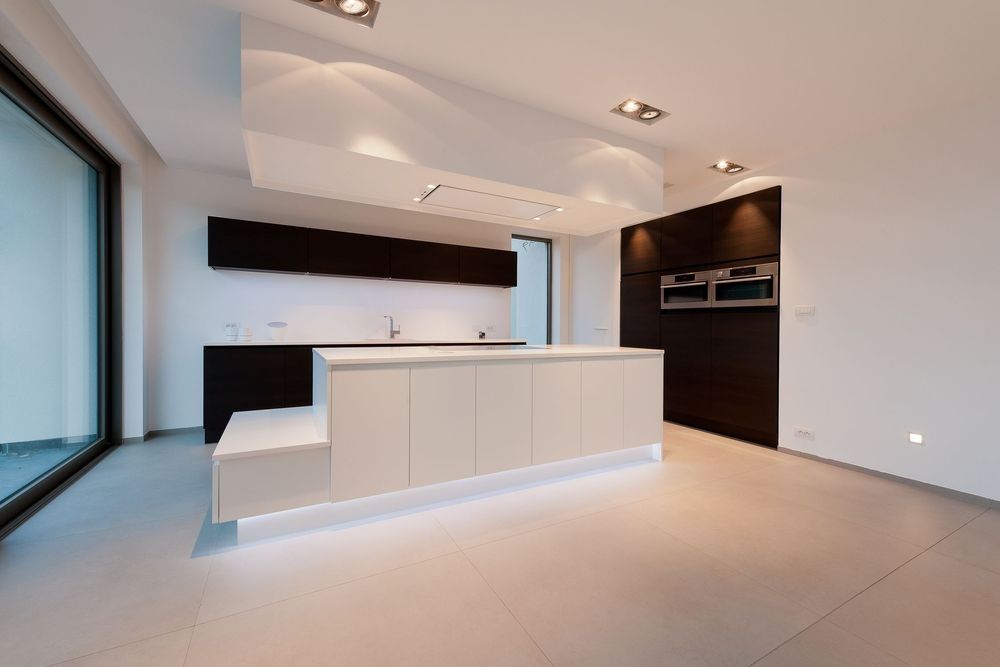 An empty kitchen with a large island in the middle