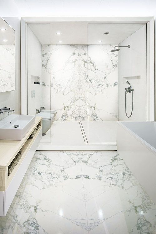 A bathroom with a walk in shower, sink, toilet and bathtub