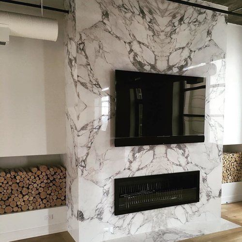 A living room with a fireplace and a flat screen tv mounted on the wall