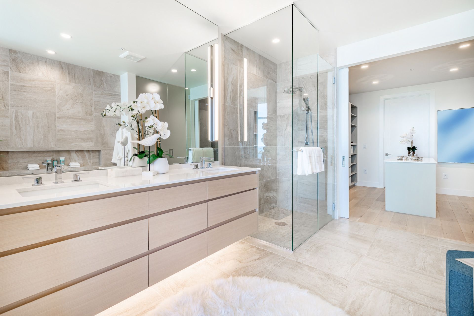 A bathroom with two sinks , a walk in shower and a tub