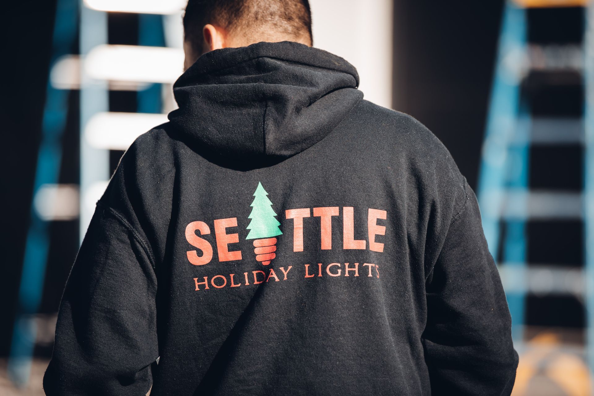A man wearing a seattle holiday light hoodie