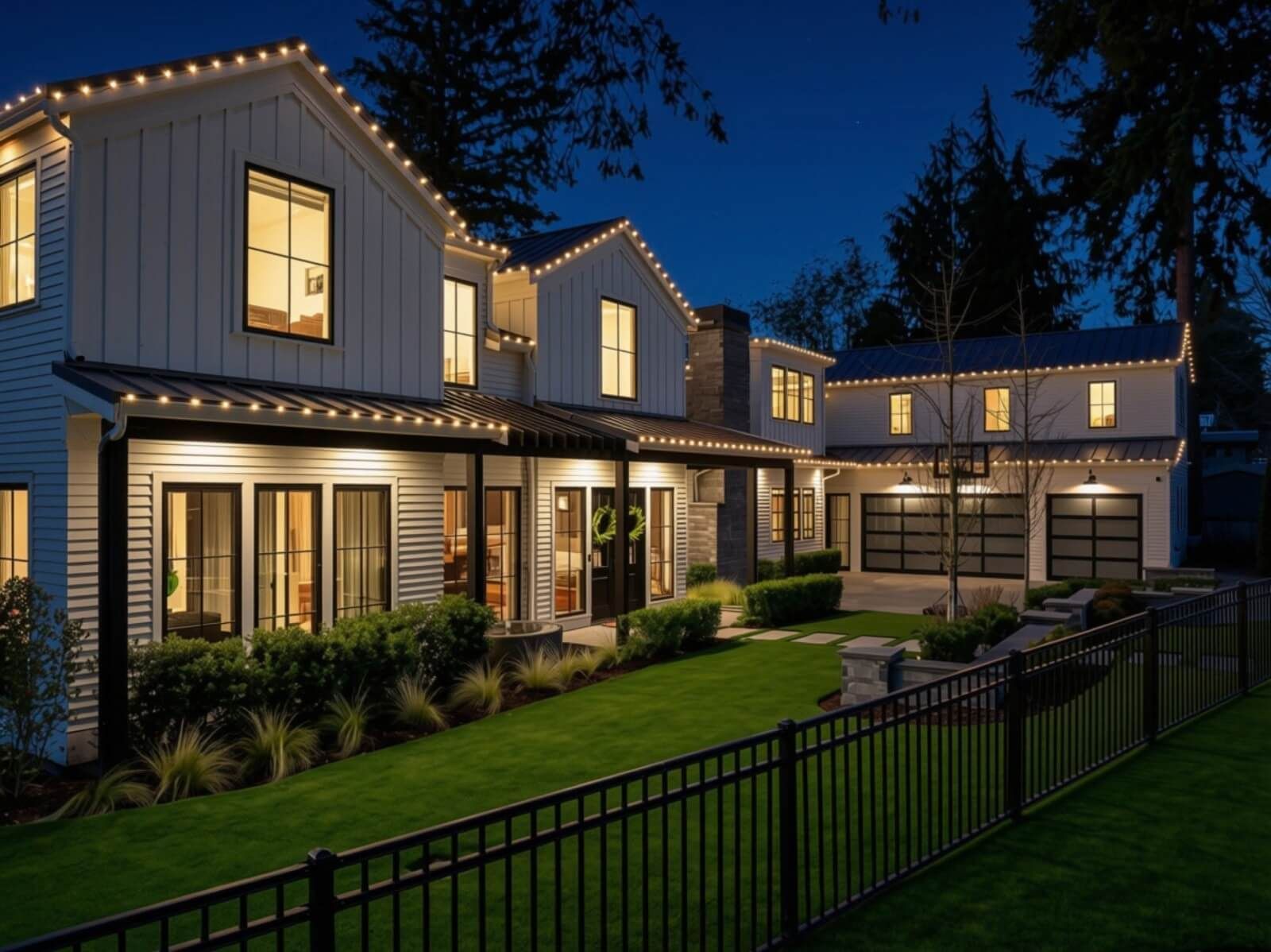 White farmhouse-style home with warm white Christmas lights on the roofline at dusk, installed by Seattle Holiday Lights