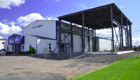 Un grand bâtiment blanc avec un toit en métal est en cours de construction.