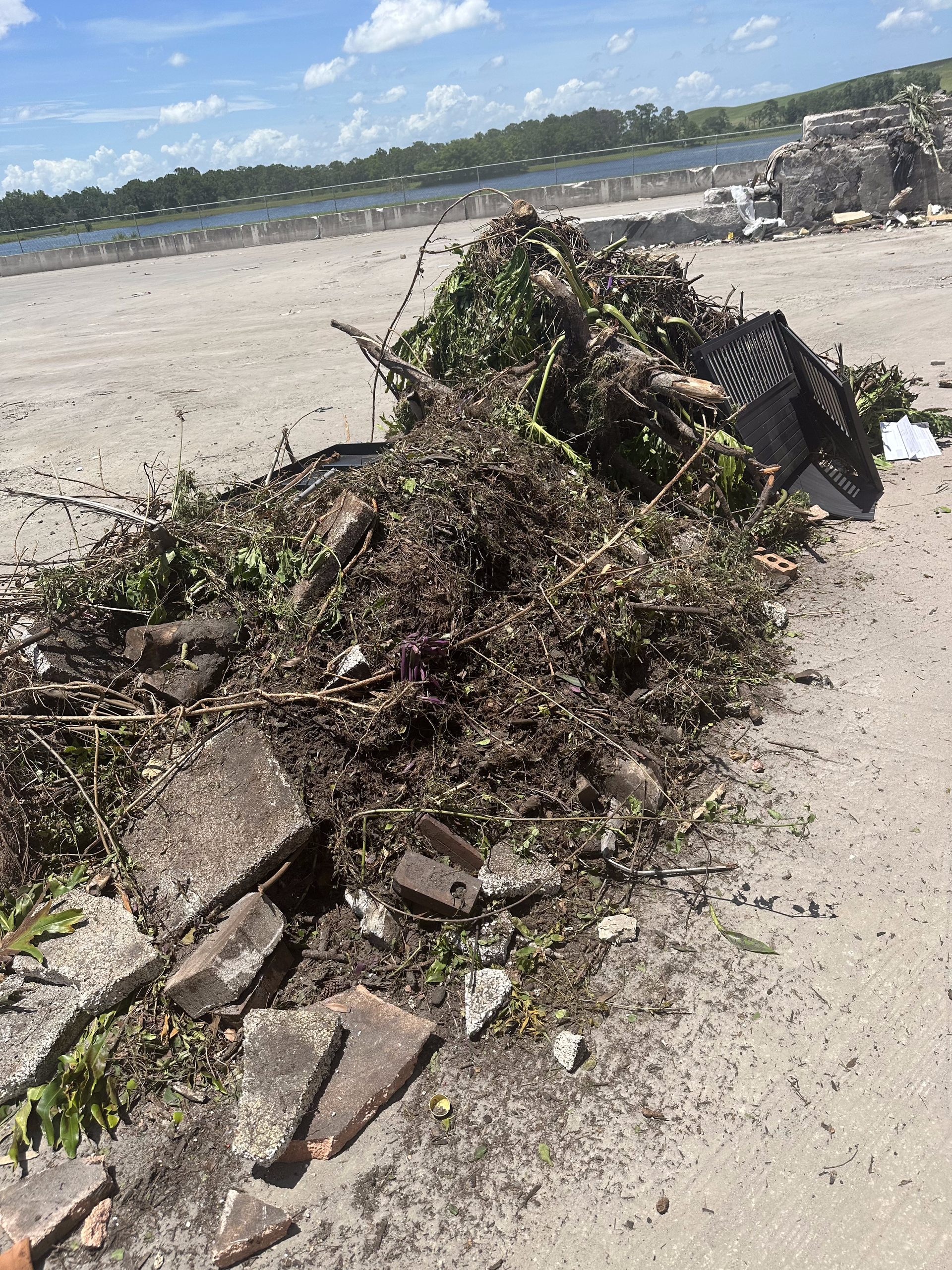 A pile of trash on a beach next to a body of water.