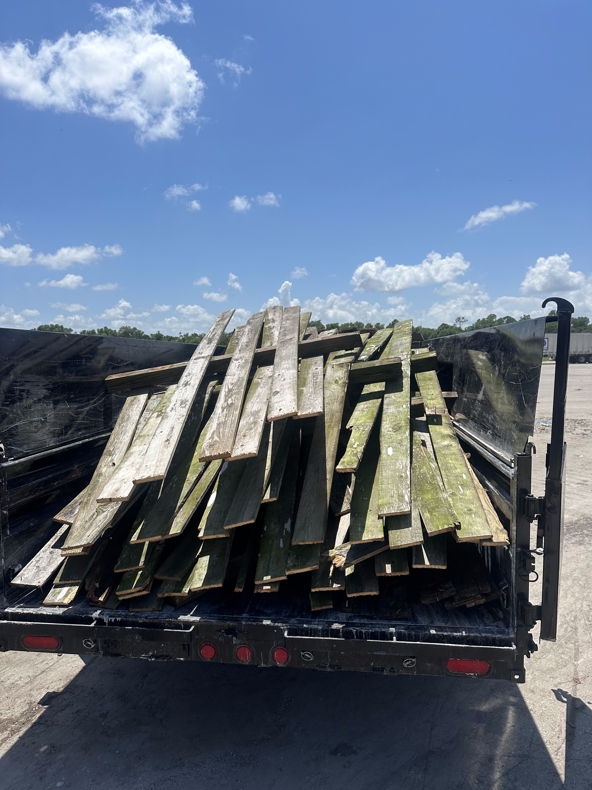 A trailer is loaded with a pile of wood.
