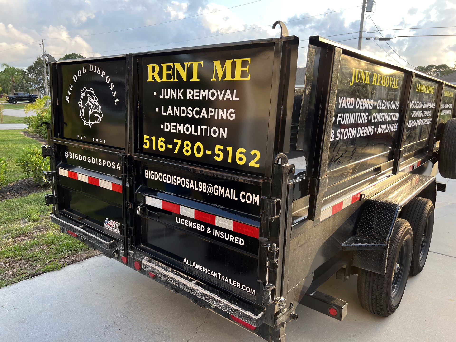 A dumpster trailer is parked on the side of the road.