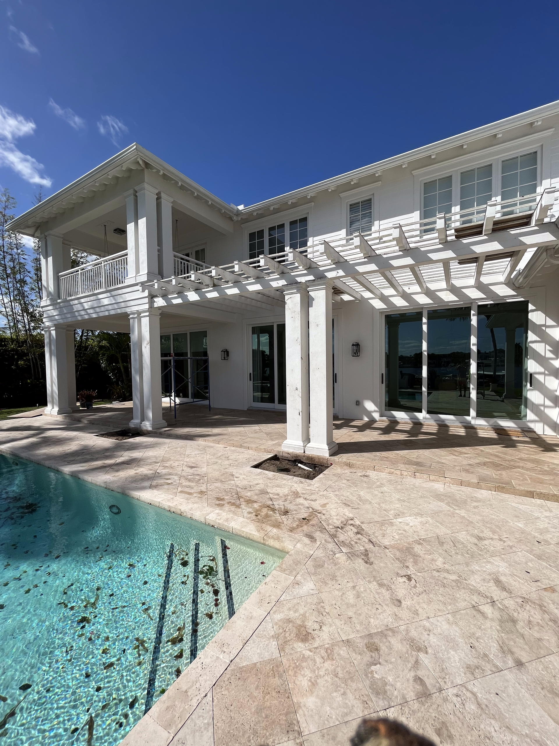A large white house with a swimming pool in front of it