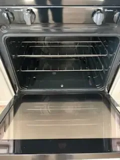 Open oven with metal racks and a clean stainless steel interior