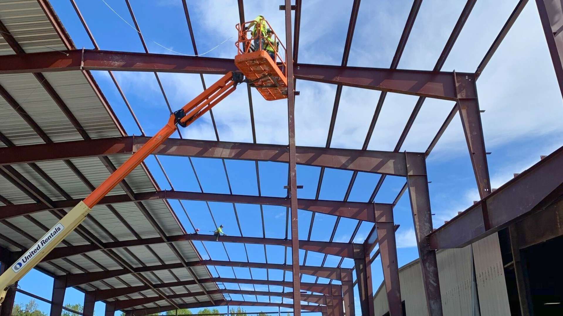 a construction worker is working on the roof of a building .